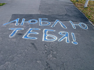 Fototapeta premium love you, blue text as graffiti on asphalt