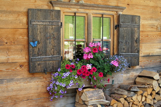 Blumenkasten vor Holzhaus