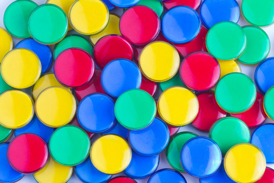 Colorful plastic playing counters on white background close up