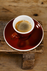 espresso coffee in thick brown cup on old wooden bench