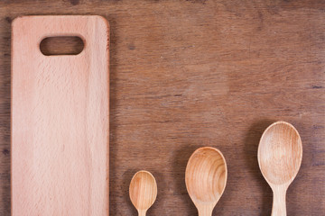 Wooden kitchen spoons on oak wood table background