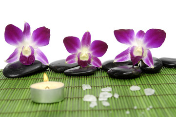 set of zen stones with orchid and candle on mat