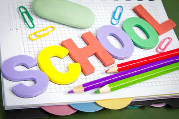 letters with pencils, paper clips, by an eraser on notebook