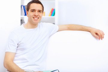 Young man at home with a book