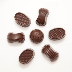 Delicious flower formed from various chocolate candies on white