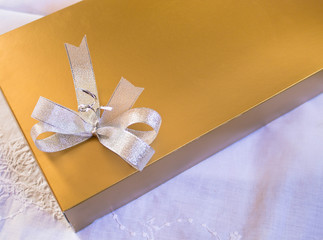 Golden gift box with  ribbon on white background