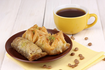Sweet baklava on plate with tea on wooden background