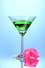 glass with cocktail and gladiolus bud