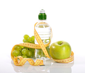 bottle with aqua, apple grapes, and measure