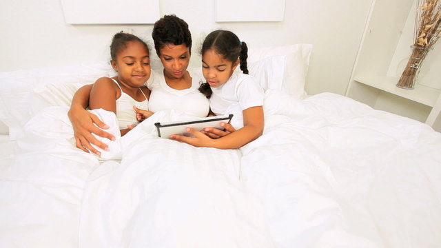 Ethnic Mother Children Using Wireless Tablet Bed
