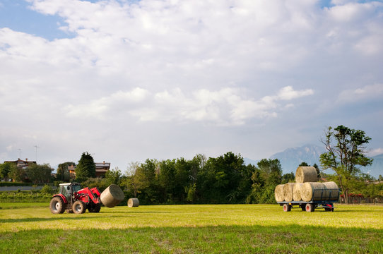 Tractor picking up hay bales landscape