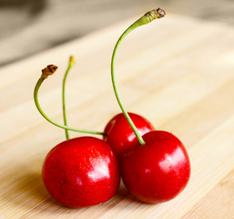 Close-up of a bunch of fresh red cherries on wooden table