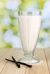 Vanilla milk shake on wooden table on bright background