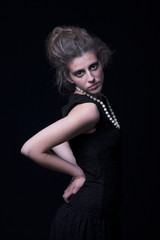 Fototapeta premium beautiful young woman with elegant black dress, on black