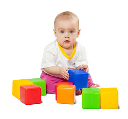 Baby girl plays with toy blocks