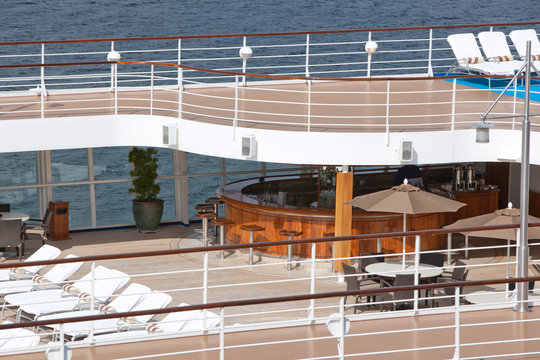 top floor of ship with deck chairs  bar view on sea