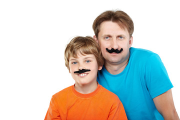 Man in t-shirt and smiling boy in orange one with mustaches