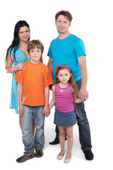 Family of four stands together holding hands