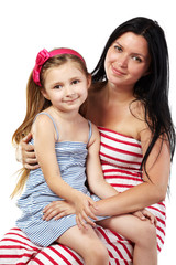 Smiling mother with little daughter on her knees