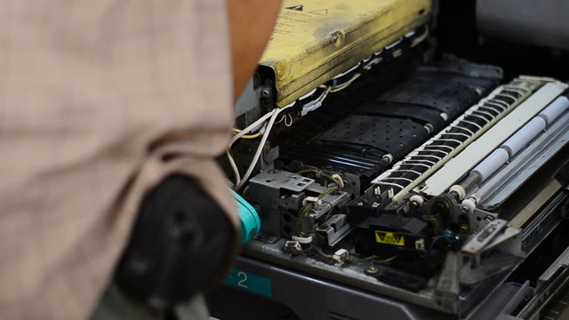 Repairman is checking a copier machine