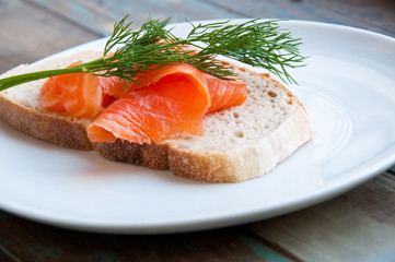 Smoked salmon on sourdough bread garnished with fresh dill.