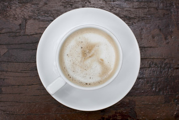 Hot coffee in a white cup on table