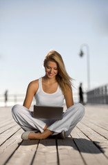 Young woman with a laptop on the pier