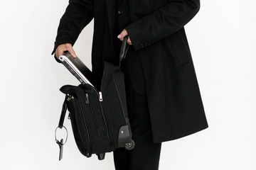Mann packt Laptop in Tasche