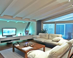 Foto op Plexiglas divano di pelle beige nel soggiorno della mansarda © adpePhoto
