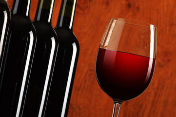 Composition with wineglass and bottles of red wine