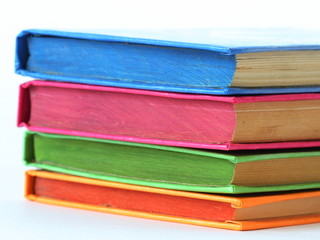 stack of bright books over white. close-up