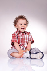 Excited little boy sitting and laughing