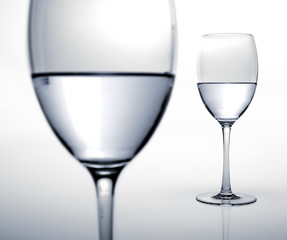 Two glasses half filled of water.