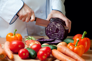 Preparing vegetables: chef cutting red cabbage-head
