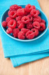 Vertical shot of a saucer full of fresh raspberries