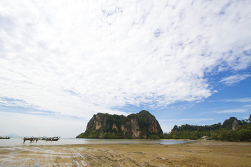 ebb beach, ebb water and island in cloudy sky