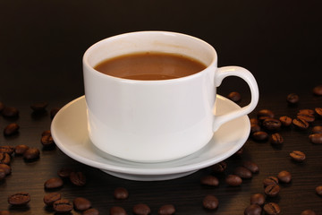 Cup of coffee on wooden table on brown background