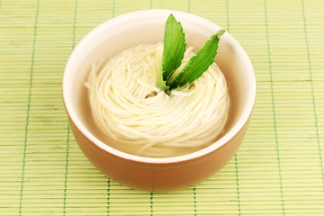 asian noodles in bowl on bamboo mat