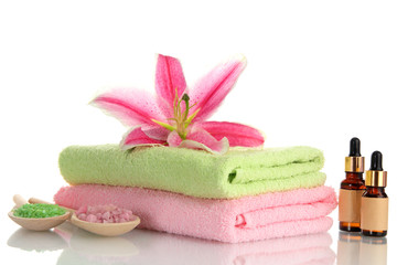 Obraz na płótnie Canvas towels with beautiful pink lily, aroma oil and sea salt