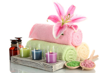 Obraz na płótnie Canvas towels with lily, aroma oil, candles and sea salt isolated