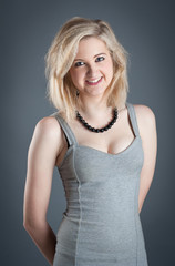 Fototapeta premium Portrait of blonde teenager girl on dark background.
