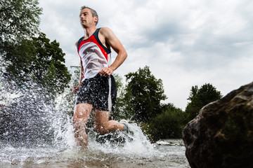 Jogger durchquert ein Bachbett