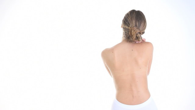 woman massaging her back, shoulders, neck