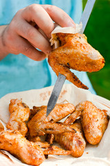 Closeup hand of a chef cook preparing grilled chicken wings