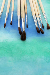 brushes on bright abstract gouache painted background