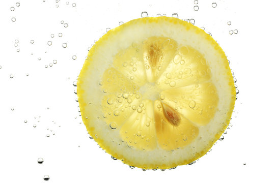 slice of lemon in the water with bubbles, isolated on white