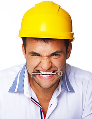 Portrait of handsome worker posing in studio with helmet and key