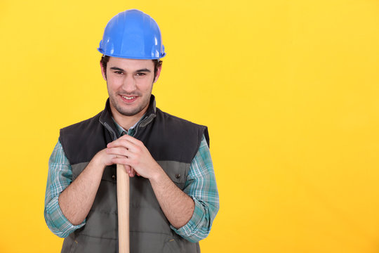 Man leaning on sledge-hammer handle