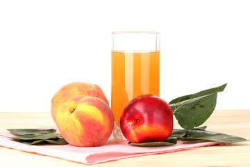 Ripe peaches and juice on wooden table on white background