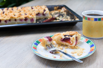 Plum cake and cup of coffee on wooden table